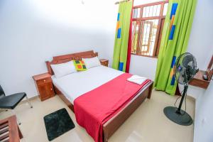 a bedroom with a bed with a fan and a window at Heritage villa polonnaruwa in Polonnaruwa