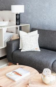 a living room with a gray couch and a table at Lamira - Serviced Apartments in Zürich