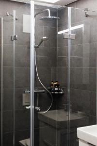 um chuveiro com uma porta de vidro na casa de banho em Lamira - Serviced Apartments em Zurique