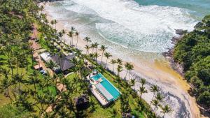 an aerial view of a beach with a pool and palm trees at São José Beach Club & Hotel in Itacaré