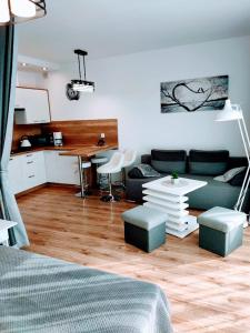 ein Wohnzimmer mit einem Sofa und einem Tisch in der Unterkunft Apartamenty Suerte in Darłówko