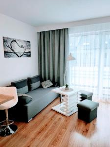ein Wohnzimmer mit einem Sofa und einem Tisch in der Unterkunft Apartamenty Suerte in Darłówko