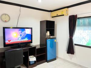 sala de estar con TV y reloj en la pared en Lamai Apartment, en Patong Beach