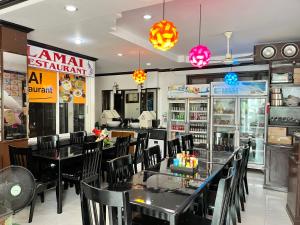 un restaurante con mesas negras, sillas y luces en Lamai Apartment, en Patong Beach
