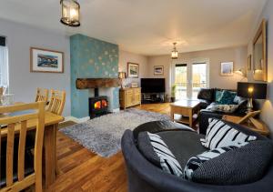 a living room with a couch and a fireplace at Drws y Llan in Llanengan