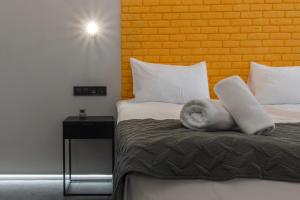 Una habitación de hotel con una cama con una toalla blanca. en Stories Hub, en Leópolis