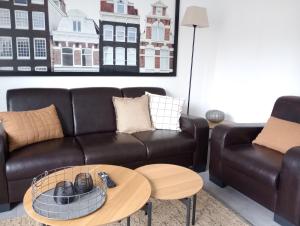 a living room with a leather couch and a table at Provinzial Ferienwohnung Walter in Wadgassen