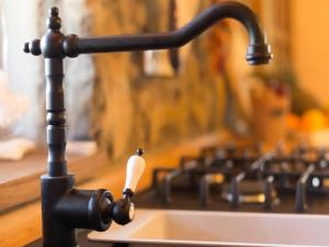 a kitchen sink with a black faucet and aaucet at Kuca Dide Juke pod Lipovcem in Gospić