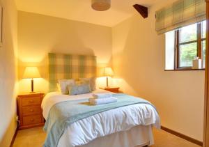 a bedroom with a bed with two lamps and a window at Swallow Cottage in Llanerchymedd