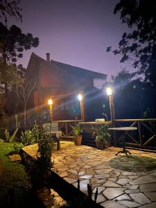 un patio por la noche con luces frente a un edificio en Pousada Casa de Mauá, en Visconde De Maua