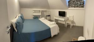 una camera con letto e scrivania con TV di Guesthouse Villa Jung a Bordighera