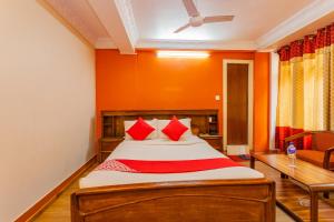 加德滿都的住宿－OYO 795 Hotel Holiday Inn，一间卧室配有红色枕头的床
