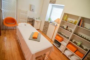 a room with a bed and a orange chair at Hotel Galant Lednice in Lednice