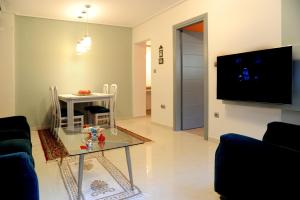 sala de estar con mesa y TV en Olive and Orange Apartment, en Mystras