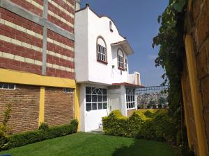 um edifício com uma porta branca e um quintal em Hospedajes Tomas Wilson MX em Cidade do México