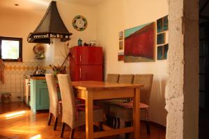 a kitchen with a wooden table and a red refrigerator at Holiday Home Natural Art House in Višnjan