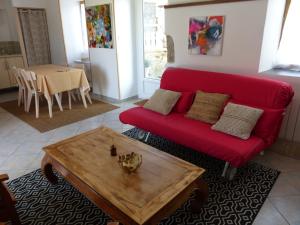 sala de estar con sofá rojo y mesa en gite d'artiste le lézard vert, en Scrignac