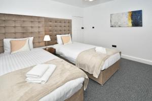 two beds in a hotel room with at Moonlight House - sleeps 7, driveway, garden in Crewe