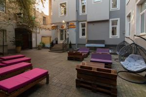 un patio con bancos con cojines morados en un edificio en Stories Hub, en Leópolis