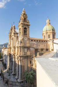 un grand bâtiment avec une tour d'horloge en haut dans l'établissement Peonia Boutique Apartments, à Palerme