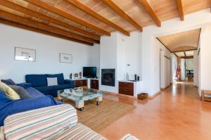 ein Wohnzimmer mit einem blauen Sofa und einem Tisch in der Unterkunft YourHouse Casa Laura, quiet villa in the countryside in Artá