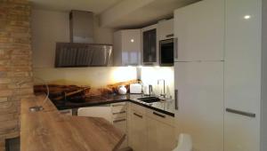 a kitchen with white cabinets and a wooden counter top at Meerblick Appartement Ostseebad Binz Prora direkt am Strand in Binz