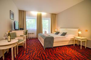 a hotel room with a bed and a table and chairs at Hotel Galant Lednice in Lednice