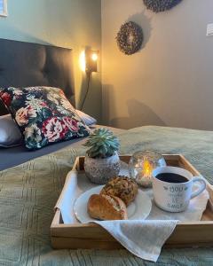 a tray with a cup of coffee and pastries on a bed at Lagerhaus Gabriel in Zweibrücken