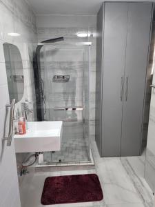 a white bathroom with a shower and a sink at Sea Views at 10 South in Durban