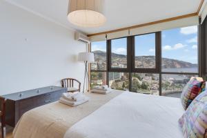 a bedroom with a large bed with a large window at Funchal View Apartment in Funchal