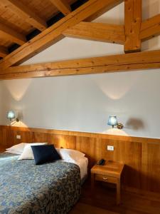 a bedroom with a bed and a wooden ceiling at Hotel Due Torri Tempesta in Noale