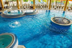a large swimming pool with two hot tubs in a resort at A Hoteli - Hotel Izvor in Arandelovac
