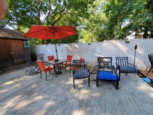 un patio con mesa, sillas y sombrilla en 34ft Mobile Home Near Yale U en New Haven