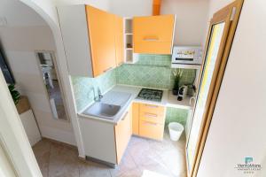 a small kitchen with orange cabinets and a sink at Vento Mare Apartments in Palau