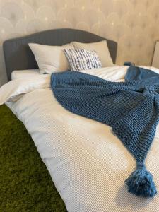 a bed with a blue blanket and pillows on it at Henriett’s cosy places in Satu Mare
