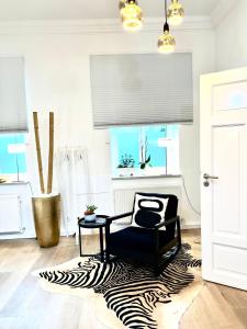 a living room with a zebra rug and a chair at Puro-Design-Apartment Deluxe - very central in Munich