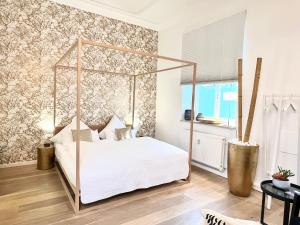 a bedroom with a canopy bed in a room at Puro-Design-Apartment Deluxe - very central in Munich