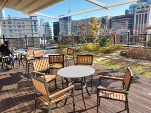 a patio with tables and chairs and a view of a city at Brown Dot Hotel Busan Station in Busan