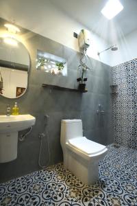 a bathroom with a toilet and a sink and a mirror at Craft Hostels in Anjuna