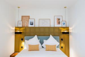 - une chambre avec un lit doté de draps blancs et d'oreillers orange dans l'établissement Maison Durante, à Nice