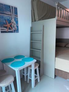 a small room with a table and chairs and a bunk bed at Lindo Studio Matinhos Prédio na beira mar. in Matinhos