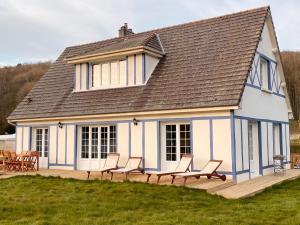 dom z krzesłami na drewnianym tarasie w obiekcie Villa Opale Etretat w Étretat
