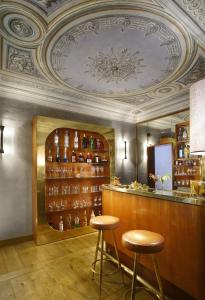 eine Bar mit zwei Hockern in einem Zimmer mit einer Decke in der Unterkunft Hotel Garibaldi Blu - WTB Hotels in Florenz
