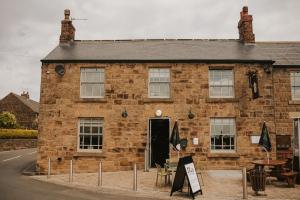 un viejo edificio de ladrillo con una mesa delante en The Devonshire Arms, en Eckington