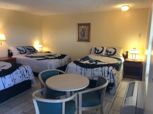米蘭諾的住宿－Motel Boutique by Wolf Inn，酒店客房带两张床和一张桌子以及椅子。