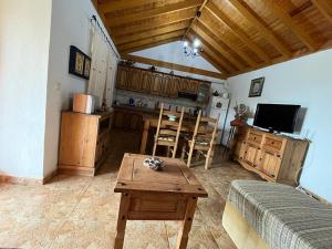 een woonkamer met een tafel en een keuken bij Casa Rural Quilla in Agulo