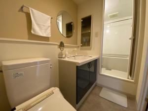 a bathroom with a toilet and a sink and a shower at AMSタワー中島 in Sapporo