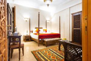 Palais Tara & Spa في مراكش: غرفة نوم بسرير وبطانية حمراء وصفراء