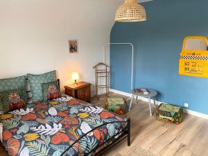 - une chambre avec un lit et un mur bleu dans l'établissement Villa Opale Etretat, à Étretat