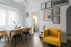 a dining room with a table and a yellow chair at Pöttyös Ponty Elegance Boutique Vendégház in Kisköre